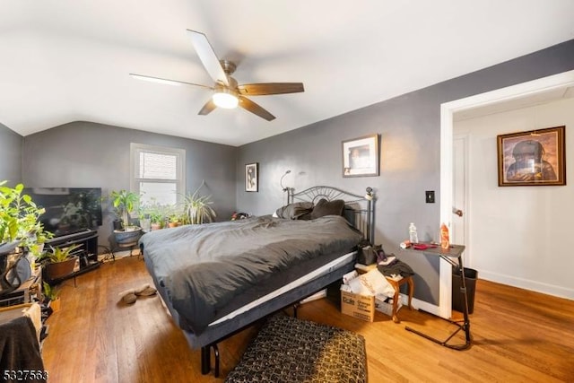 bedroom featuring wood-type flooring, vaulted ceiling, and ceiling fan