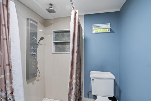 bathroom featuring a shower with curtain and toilet