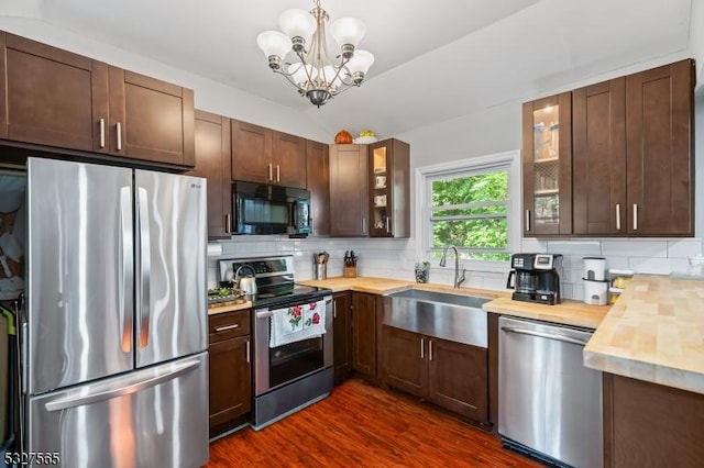 kitchen featuring butcher block counters, stainless steel appliances, an inviting chandelier, dark hardwood / wood-style floors, and lofted ceiling