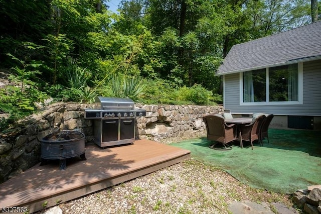 view of patio / terrace featuring a grill, a deck, and a fire pit