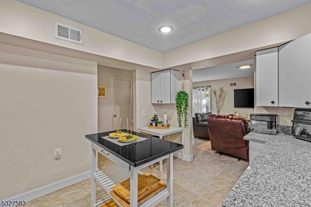 kitchen with white cabinets and light stone counters