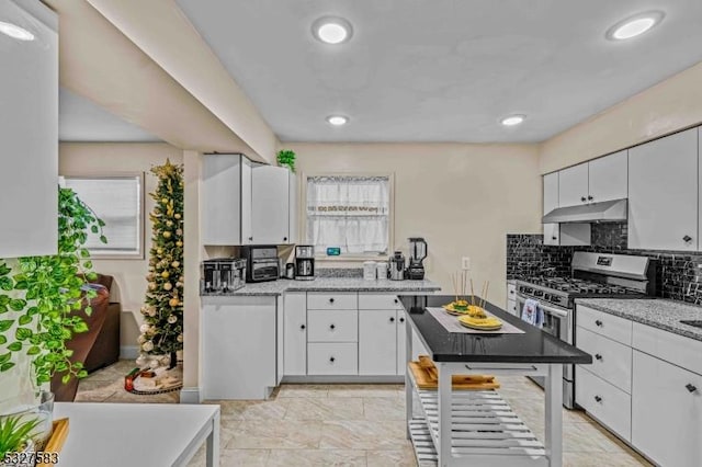 kitchen with white cabinetry, decorative backsplash, stainless steel range with gas cooktop, and light stone counters