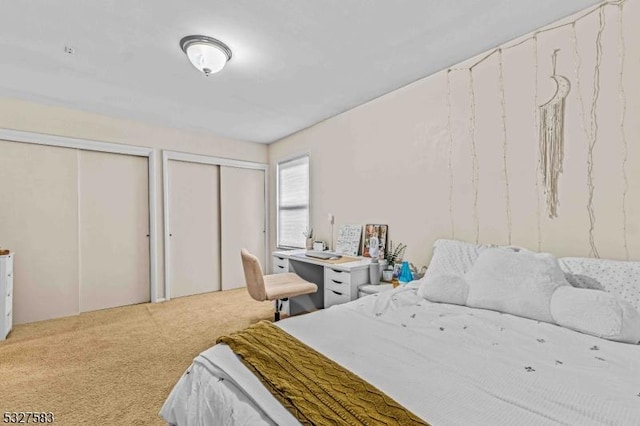 carpeted bedroom featuring multiple closets