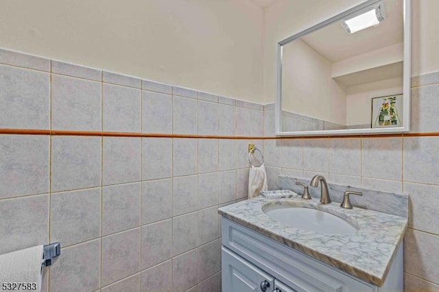 bathroom with vanity and tile walls