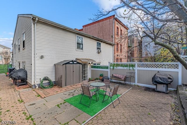 back of house featuring a shed and a patio area