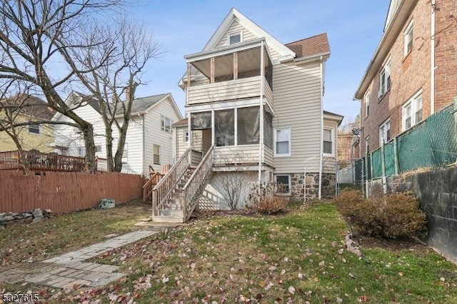 back of house featuring a sunroom and a yard