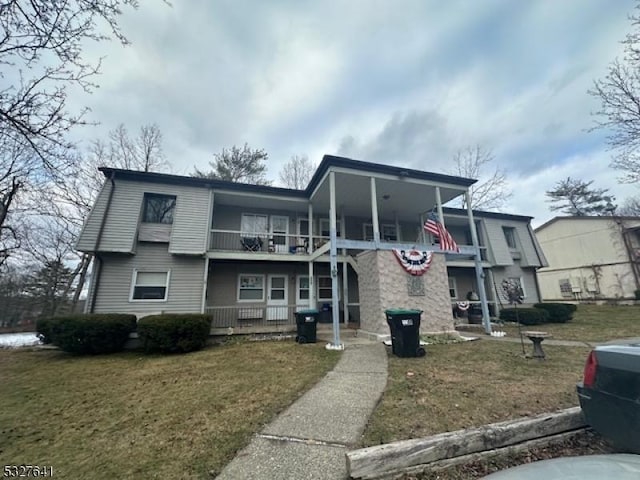 view of front of house with a front yard and a balcony