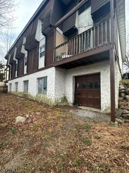 view of side of home featuring a balcony and a garage