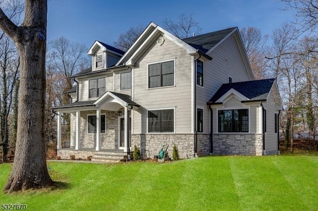 view of front of home featuring covered porch and a front yard