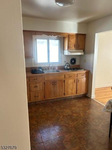 kitchen featuring tasteful backsplash, gas stovetop, and sink