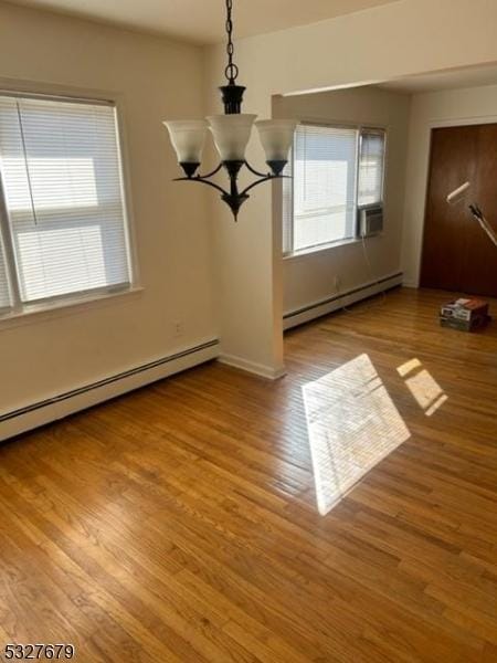 unfurnished dining area with a chandelier, light wood-type flooring, and a baseboard heating unit