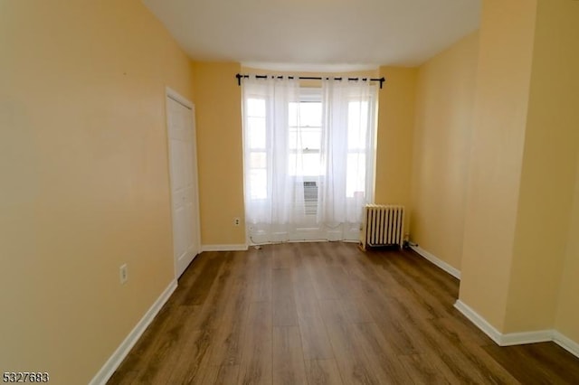 spare room with radiator and hardwood / wood-style floors