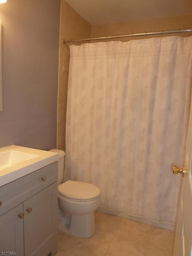 bathroom featuring tile patterned floors, curtained shower, vanity, and toilet