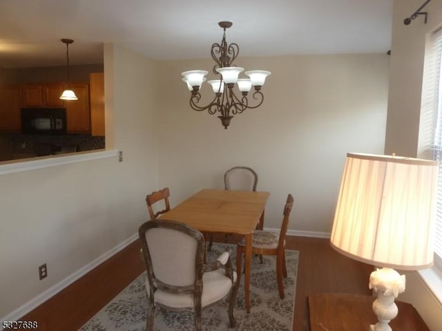 dining area featuring hardwood / wood-style floors and a notable chandelier