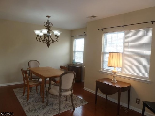 dining room featuring dark wood-type flooring and a chandelier