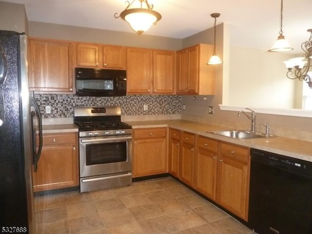 kitchen featuring sink, tasteful backsplash, hanging light fixtures, and black appliances