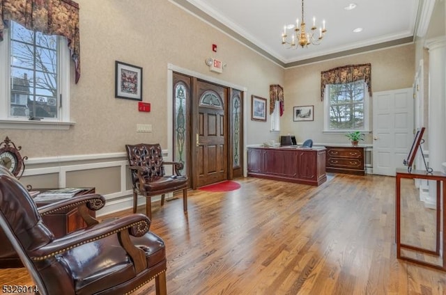 living area with crown molding, plenty of natural light, and hardwood / wood-style flooring