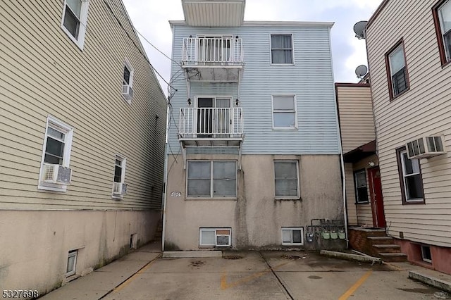 rear view of house featuring a wall mounted air conditioner