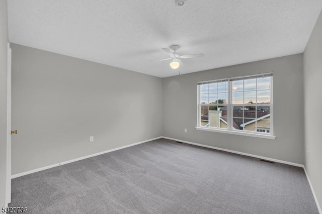 carpeted empty room with a textured ceiling and ceiling fan