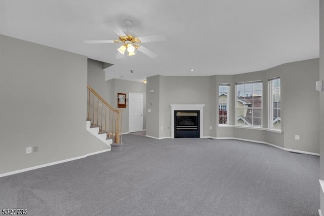 unfurnished living room featuring carpet and ceiling fan