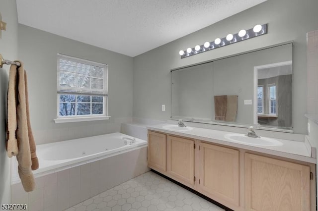 bathroom featuring tile patterned flooring, vanity, a textured ceiling, and tiled tub