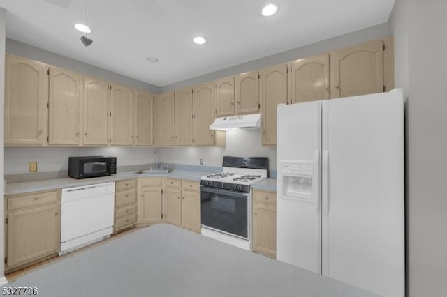 kitchen with light brown cabinets, white appliances, and sink