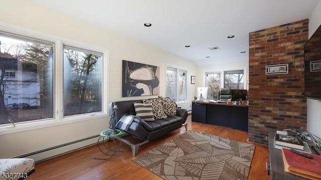 sitting room with a baseboard radiator and hardwood / wood-style flooring