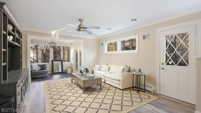 living room featuring a baseboard heating unit, ceiling fan, hardwood / wood-style flooring, and crown molding