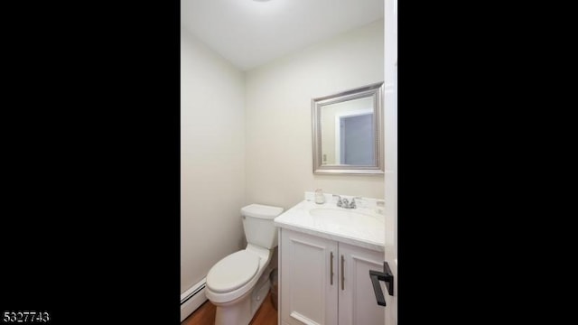 bathroom featuring toilet, wood-type flooring, vanity, and a baseboard heating unit