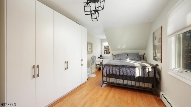 bedroom with baseboard heating and light wood-type flooring