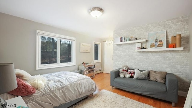 bedroom featuring a baseboard heating unit and hardwood / wood-style floors