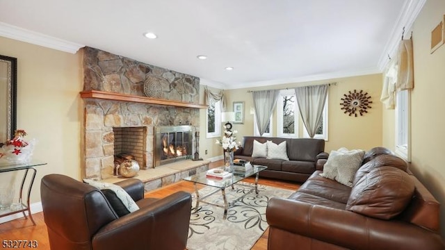 living room featuring hardwood / wood-style flooring, ornamental molding, and a stone fireplace