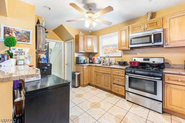 kitchen with stainless steel appliances, ceiling fan, sink, light brown cabinets, and light tile patterned flooring