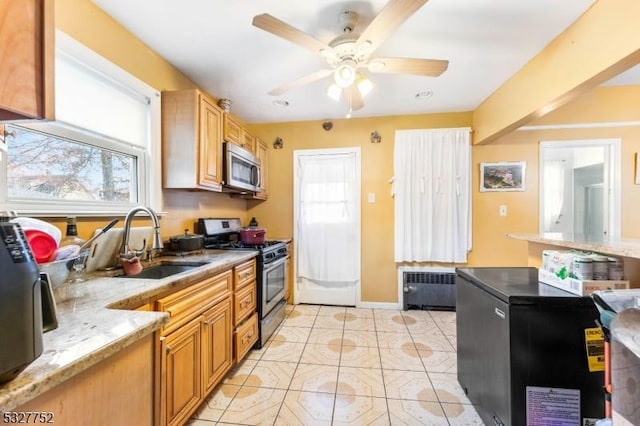 kitchen with radiator, sink, plenty of natural light, and appliances with stainless steel finishes