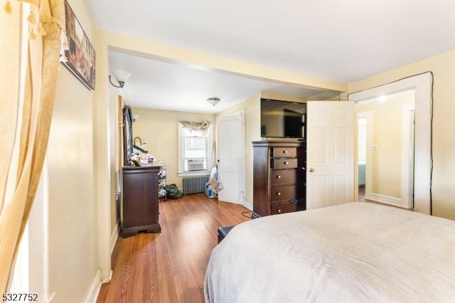 bedroom with hardwood / wood-style flooring and radiator