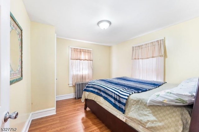 bedroom with wood-type flooring and radiator