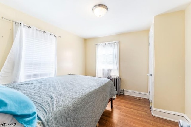 bedroom featuring radiator heating unit and wood-type flooring