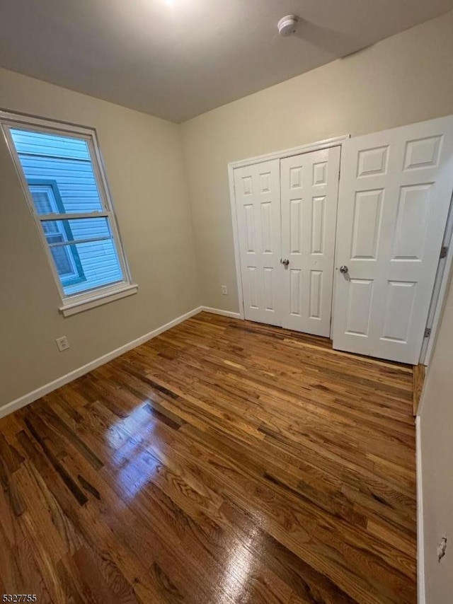 unfurnished bedroom featuring hardwood / wood-style floors and a closet