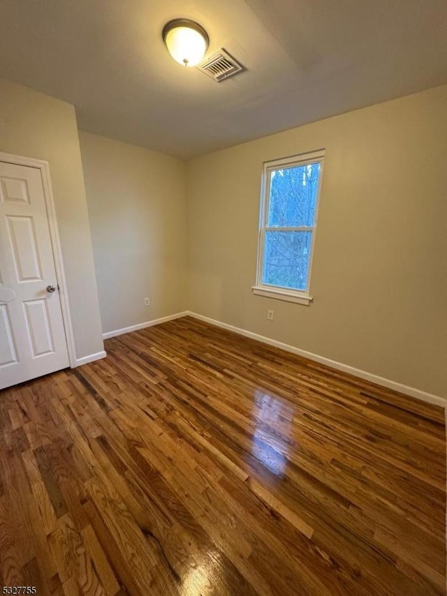 spare room with dark hardwood / wood-style flooring