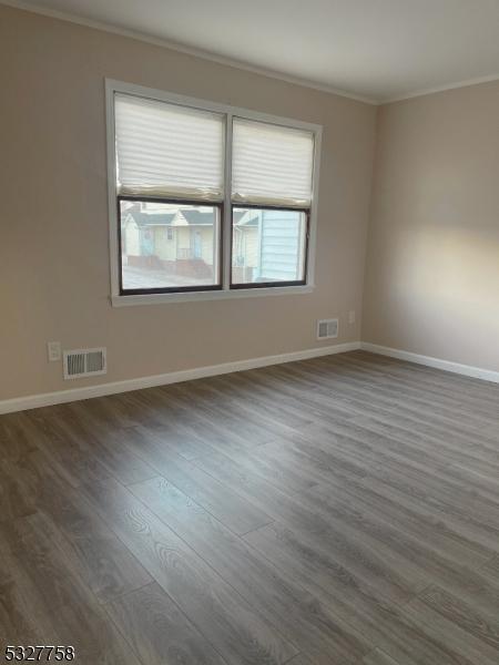 empty room featuring dark hardwood / wood-style floors and ornamental molding