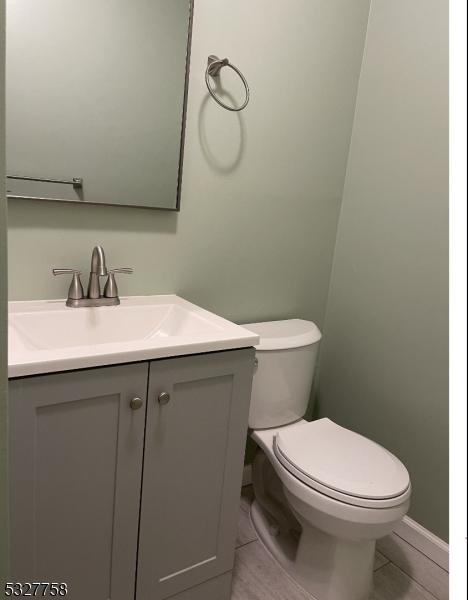 bathroom with tile patterned flooring, vanity, and toilet