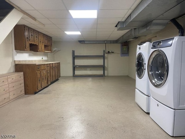 clothes washing area with washing machine and dryer and electric panel