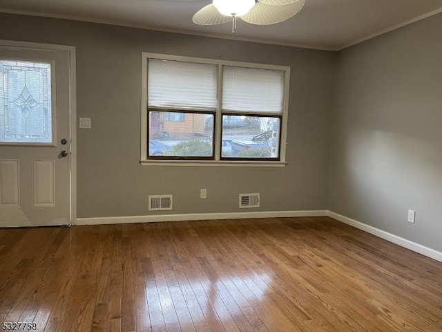 entrance foyer featuring ceiling fan, light wood-type flooring, crown molding, and a wealth of natural light