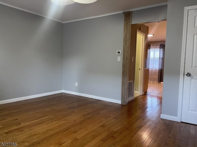 empty room featuring ceiling fan, dark hardwood / wood-style flooring, and crown molding