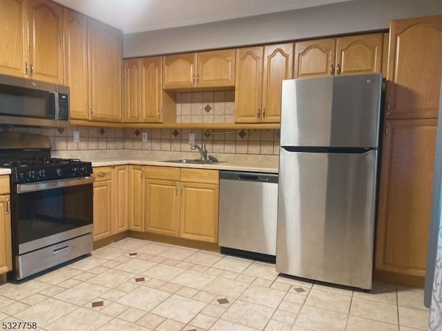 kitchen with decorative backsplash, light tile patterned floors, stainless steel appliances, and sink