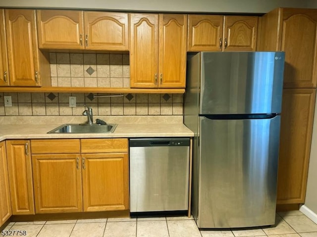 kitchen featuring light tile patterned floors, stainless steel appliances, tasteful backsplash, and sink