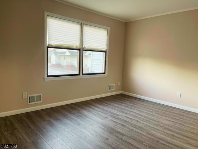 empty room featuring hardwood / wood-style floors and crown molding