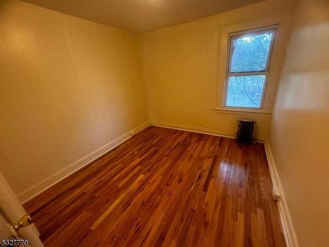 empty room featuring hardwood / wood-style flooring and radiator