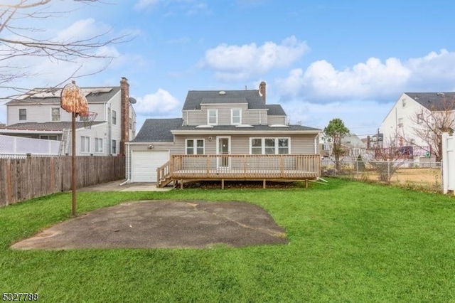 back of property with a wooden deck, a yard, and a garage