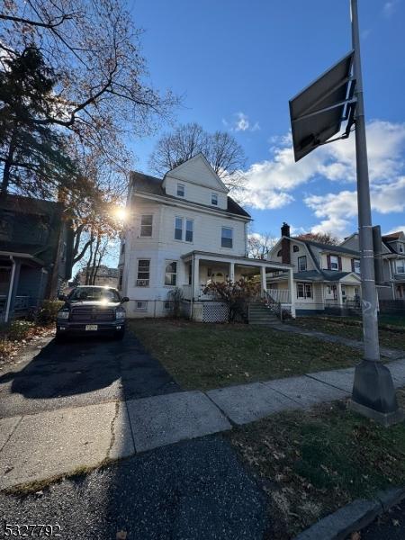 view of front of property featuring covered porch and a front lawn